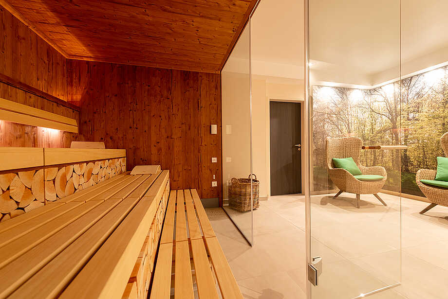 Sauna with a view of two wicker chairs in the "WaldSpa" - Hotel Munte