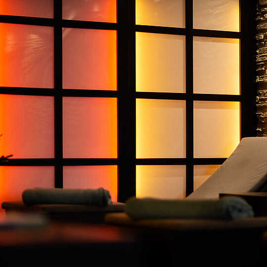 A wooden lounger in a pleasantly lit relaxation room