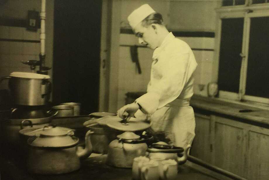 schwarz-weiß Foto eines Kochs in der damaligen Küche