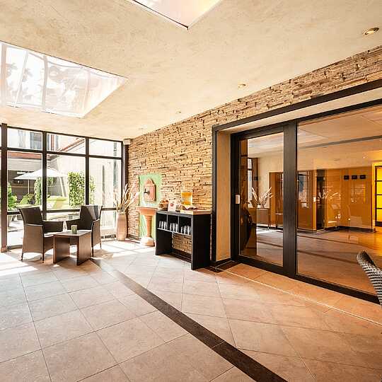 Lounge mit braunen Stühlen und einem Steinwandbrunnen