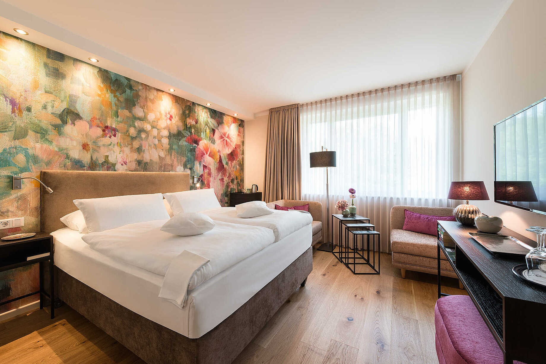 Zimmer der Kategorie Auszeit mit einer Blumentapete im Hotel Munte am Stadtwald