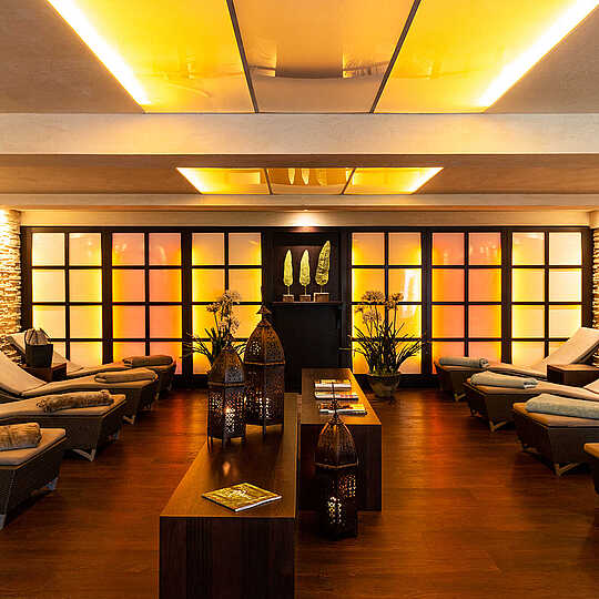 several loungers with blankets and towels in a room with lighting effects