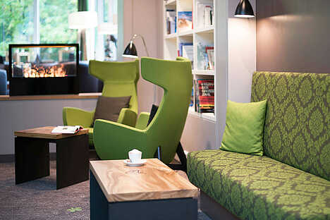 Gemütliche Lobby mit grünen Sessel - Hotel Munte am Stadtwald Bremen