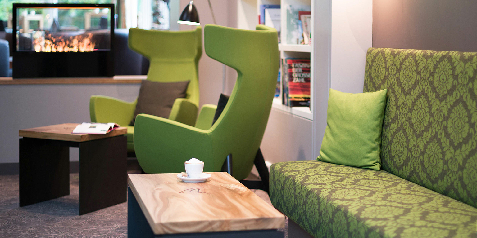 Kaffeetrinken auf einer grünen Couch in der Hotellobby Lounge