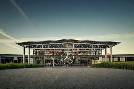Mercedes-Benz Kundencenter Außenaufnahme - Gebäude ist sehr verglast mit dem Mercedes Stern in der Mitte