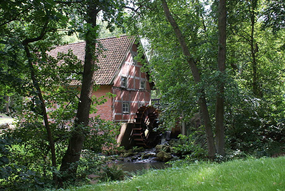 Alte Wassermühle an einem Reetdachhaus