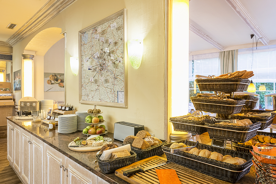 Blick auf das Frühstücksbuffet mit Brot- und Brötchenauswahl, Kuchen, Käseauswahl, Obstetagere, Konfitüre und Honig
