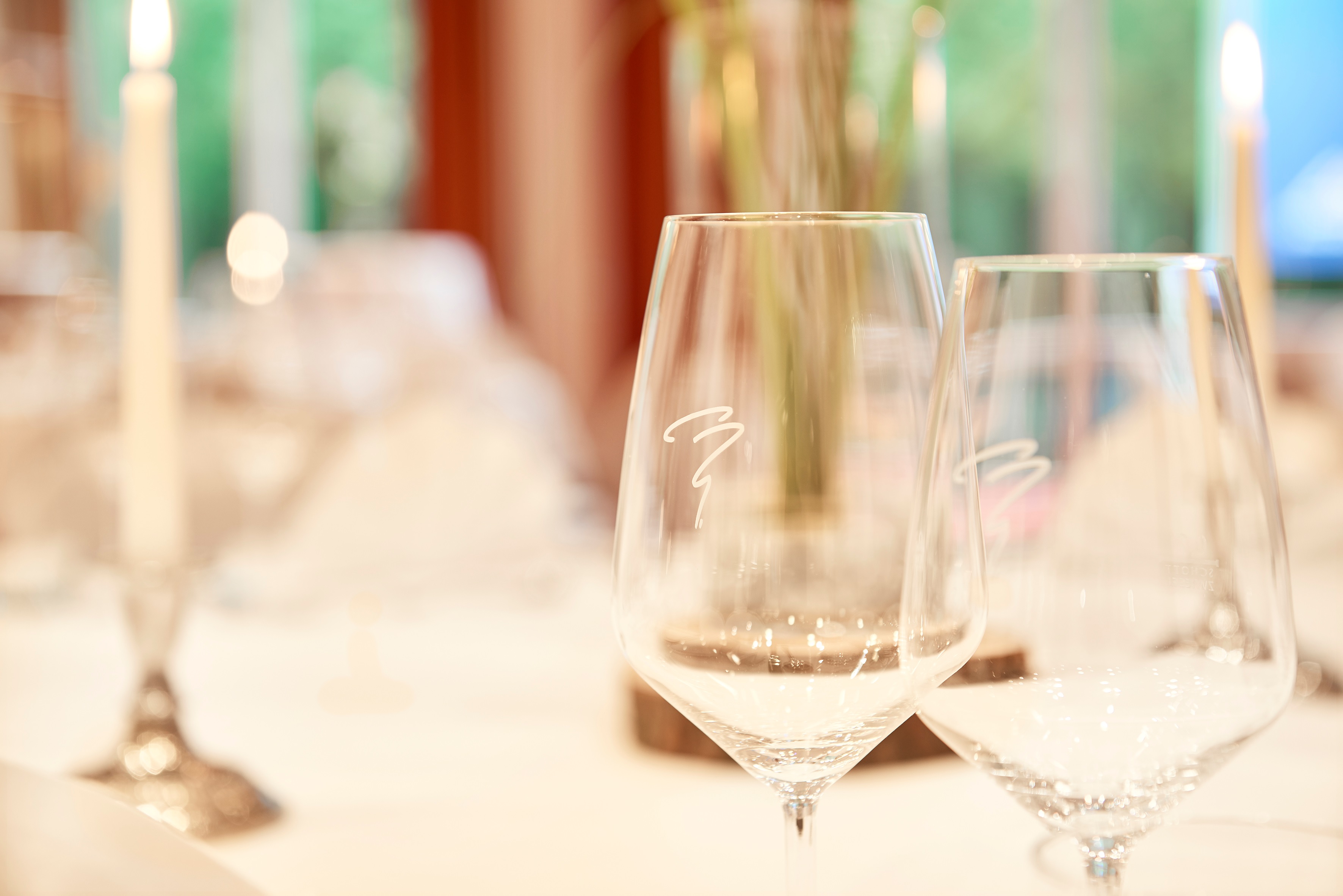 Nahaufnahme eingedeckter Tisch und Gläser mit Hotel Munte Logo